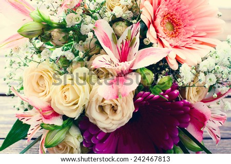 Flowers. Wedding bridal bouquet of white roses and pink lilies on  wooden table, close-up