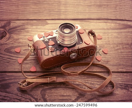Retro Camera with red hearts on a wooden background. Valentine's Day greeting card