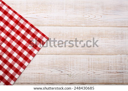 Wooden table covered with tablecloth. View from top. Empty tablecloth for product montage. Free space for products and for your text