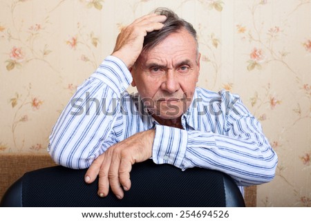 Elderly man grieves at home. Single people. Man upset headache