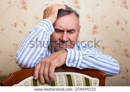 Elderly man grieves at home. Single people. Man upset headache