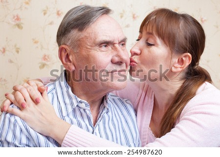 Senior father. Family adult daughter kissing senior father. Elderly man with her caregiver at home.