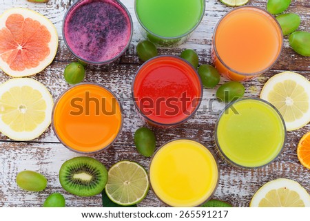 Glasses of tasty fresh juice, on wooden desk. Unusual top view