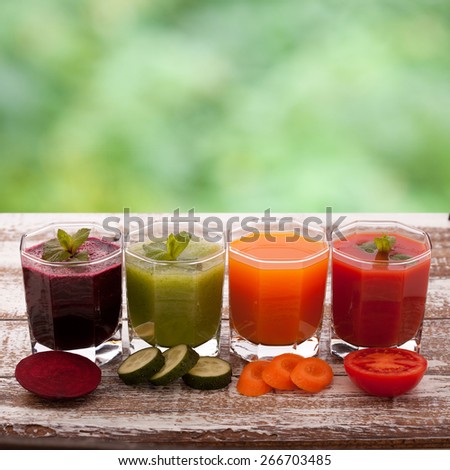 Tomato, cucumber, carrot, beet juices and vegetables on white wooden table top view.