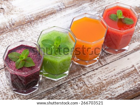 Tomato, cucumber, carrot, beet juices and vegetables on white wooden table top view.