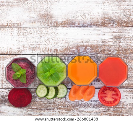 Tomato, cucumber, carrot, beet juices and vegetables on white wooden table top view. Closeup selective focus