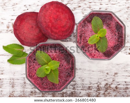 Beet juices and vegetables on white wooden table top view. Closeup selective focus