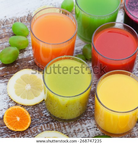Fruit and vegetable juice in glasses and fresh fruits on wooden table summer background
