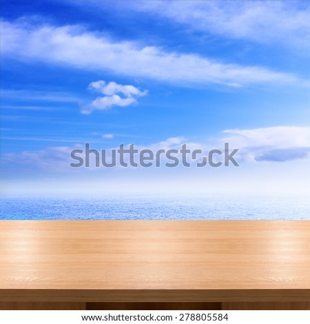 Empty wooden desk for product montage texture background wallpaper. Blue sea and clouds on sky beach and tropical sea. Stand for product showcase.