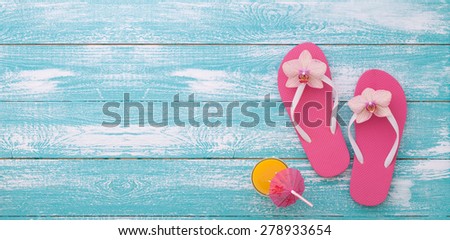 Summer vacation. Pink sandals and beach accessories on wooden background. Flat mock up for design.