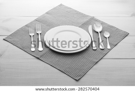 Empty plates and cutlery on table cloth on wooden table for dinner. Top view. Flat mock up for design.