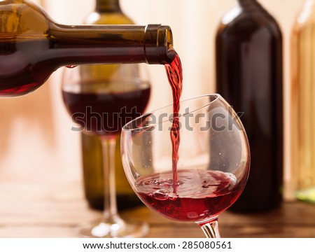 Red wine pouring into wine glass, close-up. Flat mock up for design.