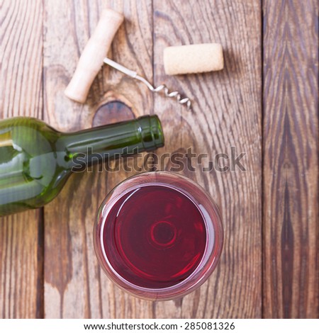 Glass of wine and bottle on wooden background. Flat mock up for design.