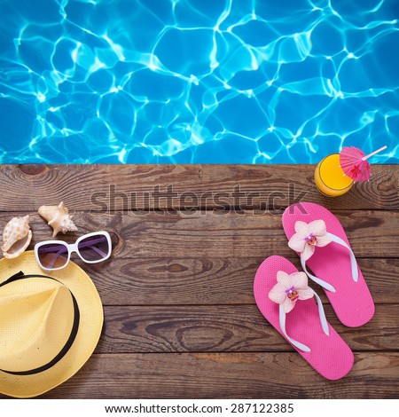 Fashionable clothes sunglasses, hat, flip-flops for beach holiday. Orange juice. Flat mock up for design. Top view. Summer vacation concept.