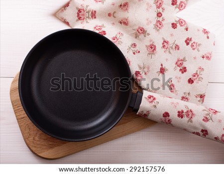 Empty pan on wooden deck table with tablecloth. Flat mock up for design. Top view.