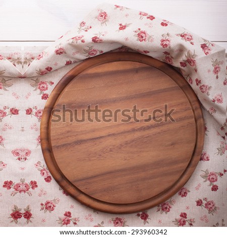 Empty kitchen cutting board. Wooden table covered with tablecloth. View from top.