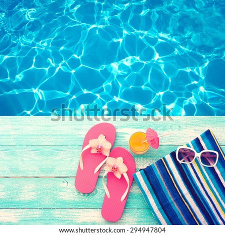 Summer vacation. Pink sandals by swimming pool. Blue sea surface with waves, texture water. Beach accessories. Flat mock up for design. Beautifully toned image