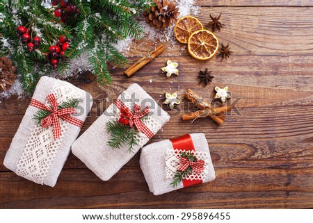 Christmas gift boxes decorated with fir branches for the new year on wooden texture
