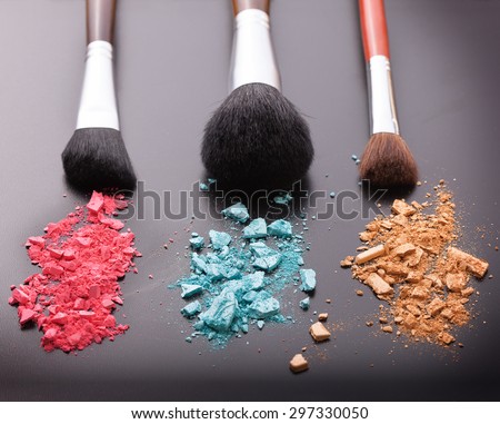 Makeup brush with powder foundation on black background