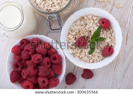 Summer breakfast. Ingredients for healthy breakfast - berries, fruit and muesli on white wooden table, close-up top view horizontal.