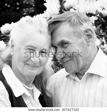 Senior Couple Relaxing In Summer Garden. Black and white photo, square