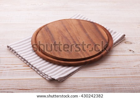 Pizza board with a napkin on white wooden table. Top view mock up