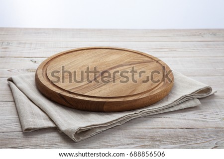 Pizza board and canvas napkin with lace on wooden table. Top view mock up
