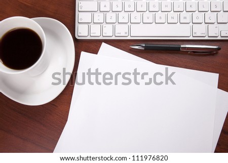 cup of coffee keyboard piece of paper and pen on the table
