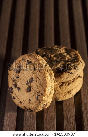 chocolate chip cookies and chocolate pieces on deck background