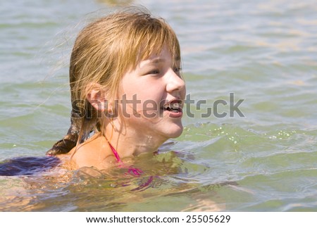 The cheerful girl swimming in the sea