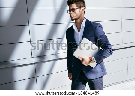 Walking business man. Elegant young handsome man wearing glasses and watchers.