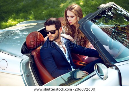 Sexy couple in the car. Luxury life.