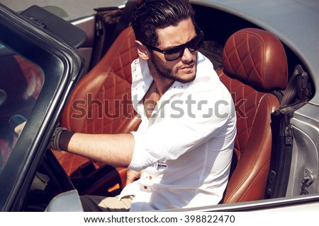 Handsome man in the car. Luxury life.