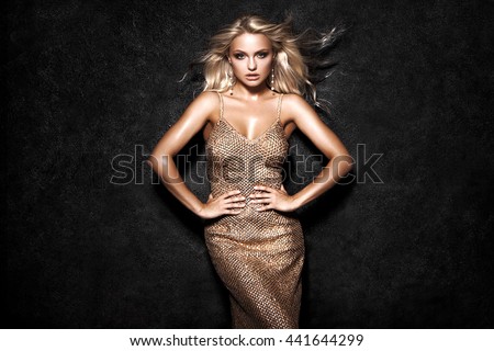 Beautiful sexy blonde woman on black background, party.