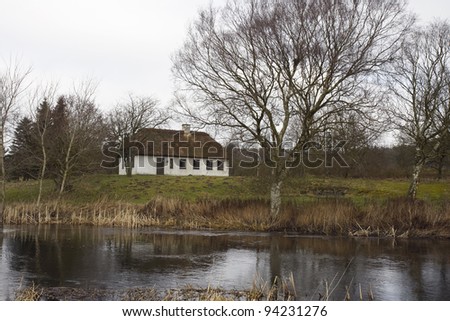 Cottage with thatched roof at the river Gudenaa, Denmark