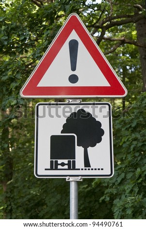 Road sign warning against trees close to the road. Shot from Germany