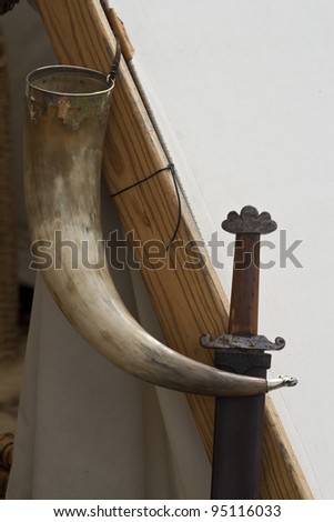 Viking drinking horn and sword hanging on a Viking tent