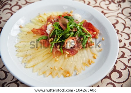 Aristocratic Appetizer - Sliced Melon and Proshutto Carpaccio with mozzarella , Herbs, Rocket leaves and Cherry tomatoes