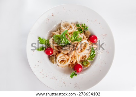 Top view  Plate of Seafood Pasta with squid, mussels with cream, decorated with cherry tomatos, olives, parmesan and herbs on the white plate isolated