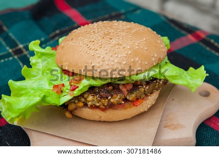 Healthy Vegetarian Sreet food  - burger with falafel, and vegetables on wooden board close up selective focus