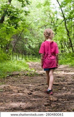 Little Girl Stands Alone On A Beautiful Forest Path