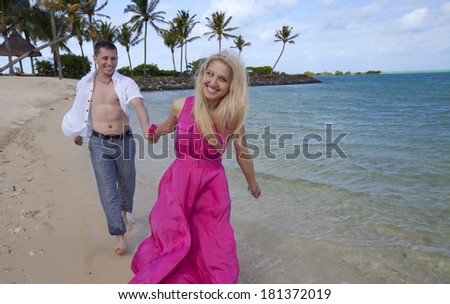 Happy couple walking on tropical  sand beach. Mauritius.