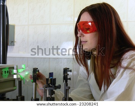 The young nice woman-scientist check the laser focussing with a small leaf of paper.