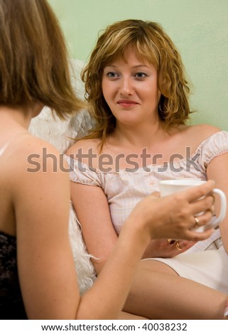 Two women friends chatting over coffee or tea