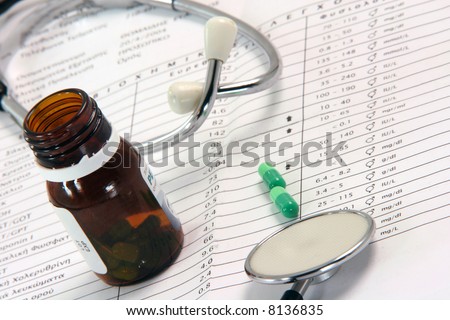 stethoscope sheet of medical lab test results and bottle of medicine capsules
