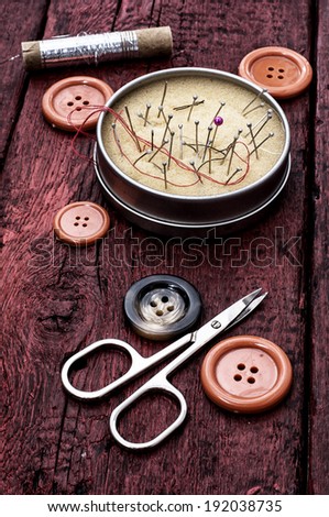 scissors and the thread on the painted red plates
