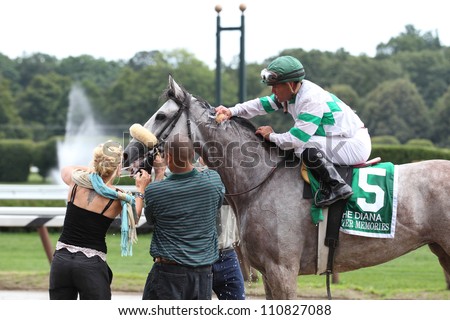SARATOGA SPRINGS, NY - JULY 28: Jockey Javier Castellano aboard Winter Memories gets a cool sponge of water after winning The Diana Stakes on July 28, 2012 Saratoga Springs, New York