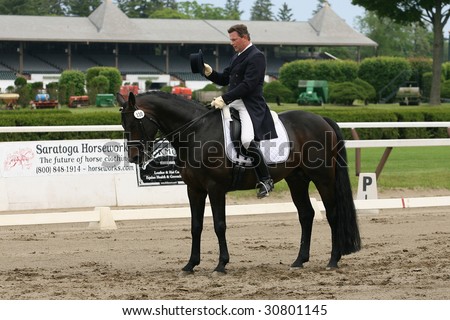 SARATOGA SPRINGS - MAY 23: Harry Diel salutes the judge after riding Carry On F. Gamdaard in Adult Amateur Division at the Dressage May 23, 2009 in Saratoga Springs, NY.