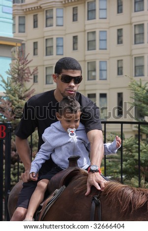 ATLANTIC CITY - JUNE 25: Juan Manuel Lopez current WBO super bantamweight rides a horse and holds his daughter for the media on the Boardwalk at Bally\'s Casino - June 25, 2009 in Atlantic City, NJ