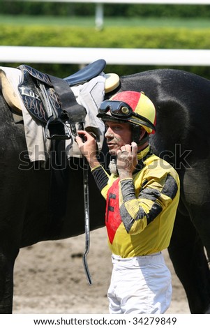 ELMONT, NY- JULY 25: Michael Luzzi prepares to remove the saddle from Living Out a Dream after the forth race at Belmont Park- July 25, 2009 in Elmont, NY.